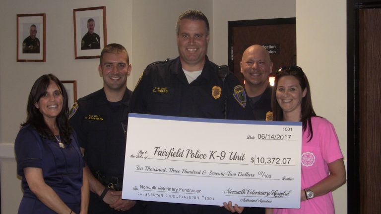 Dr. Duffy of the Norwalk Veterinary Hospital and Sue Gabriel present a check to the Fairfield Police K-9 Division